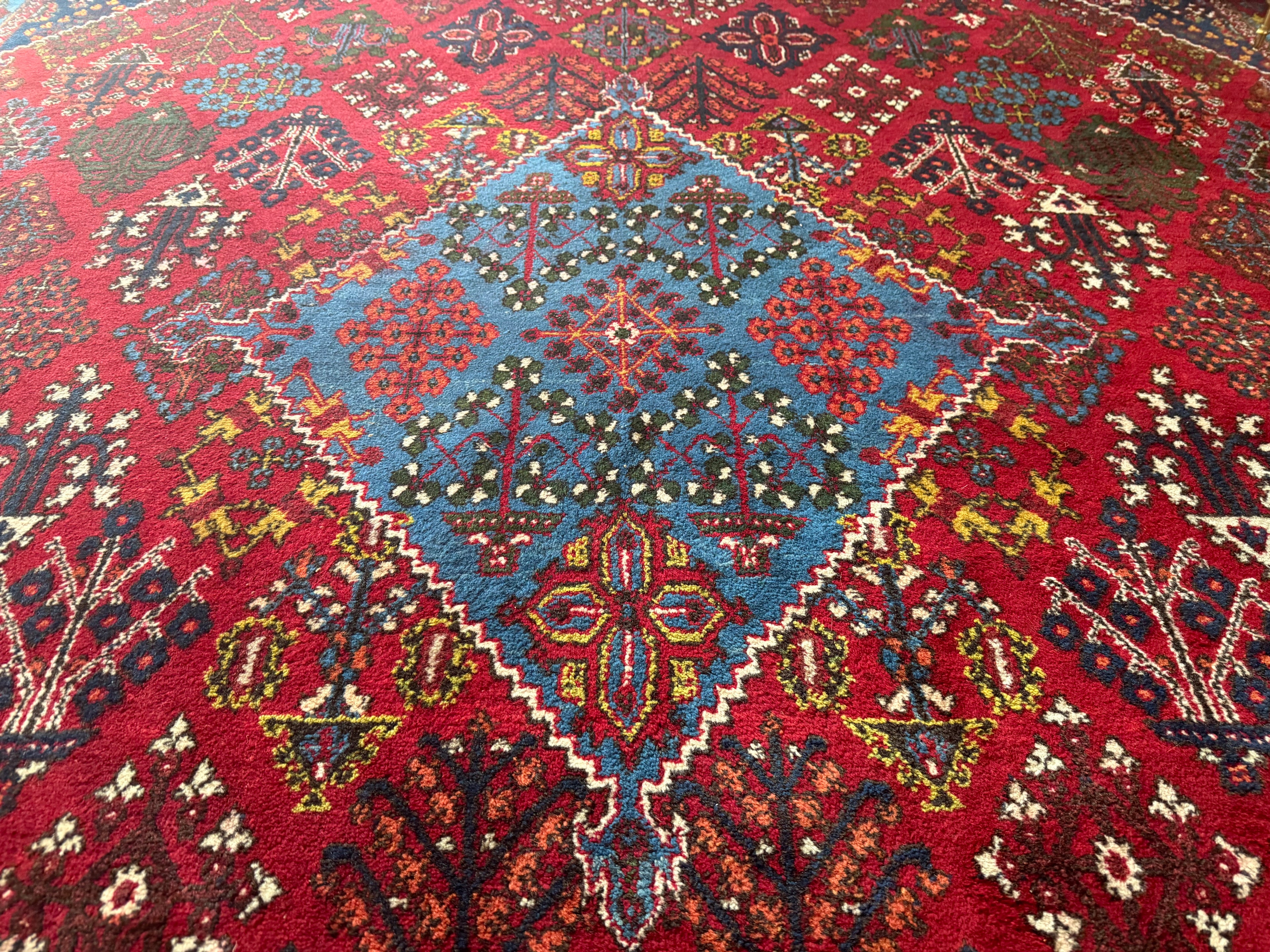 Groot vintage tribaal tapijt 355 × 241 cm – rood veld met blauw medaillon