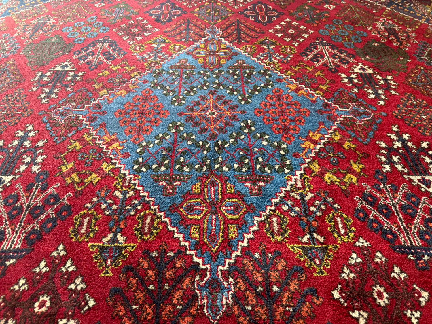 Groot vintage tribaal tapijt 355 × 241 cm – rood veld met blauw medaillon