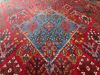 Groot vintage tribaal tapijt 355 × 241 cm – rood veld met blauw medaillon