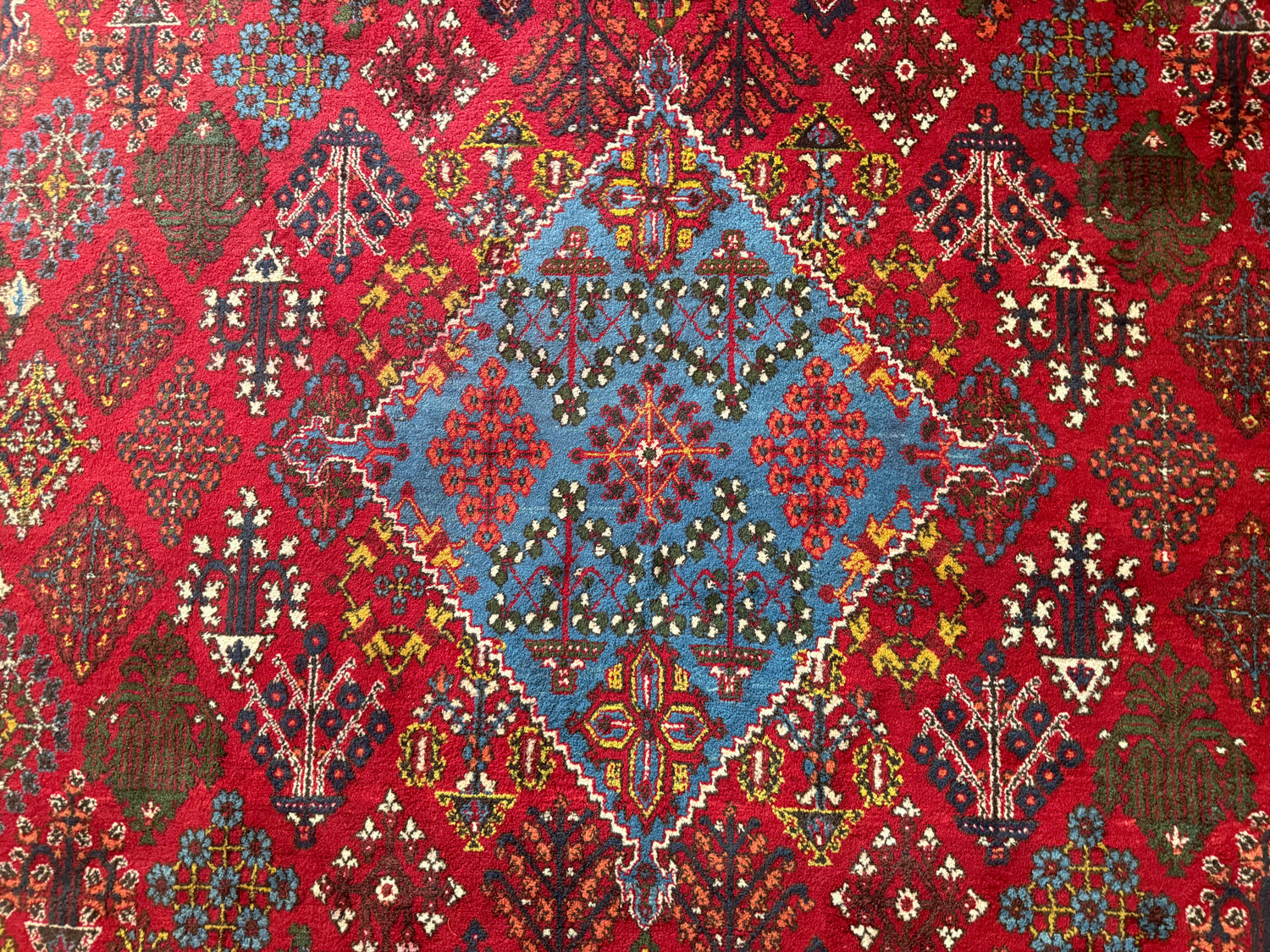 Groot vintage tribaal tapijt 355 × 241 cm – rood veld met blauw medaillon